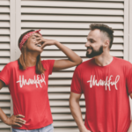 two people smiling, with the word thankful on their t-shirts